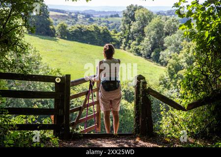 Femme ouvrant la porte marchant le sentier Offa's Dyke longue distance dans la campagne galloise du Monmouthshire près de Llangattock Lingoed, Monmouthshire, pays de Galles Banque D'Images