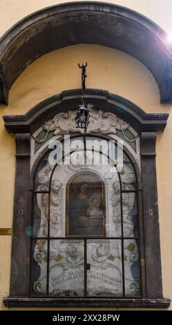 Gros plan avec des reflets de lentille de l'ancien tabernacle de la Vierge à l'enfant dans la via Sant'Antonino, dans le centre historique de Florence, Toscane, Italie Banque D'Images