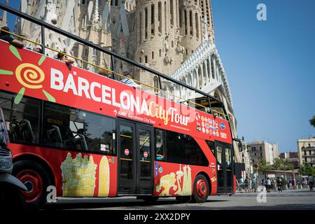 Barcelone, Espagne. 21 août 2024. Un bus touristique passe par l'église de la Sagrada Familia. Avec plus de 18 millions de touristes attendus à Barcelone en 2024, la ville peine à trouver un équilibre entre les avantages économiques du tourisme pendant la saison touristique et la nécessité de garder la ville vivable pour les résidents locaux, qui font preuve d'hostilité envers le tourisme de masse et l'exploitation de la ville par l'industrie du tourisme. (Photo Davide Bonaldo/SOPA images/SIPA USA) crédit : SIPA USA/Alamy Live News Banque D'Images