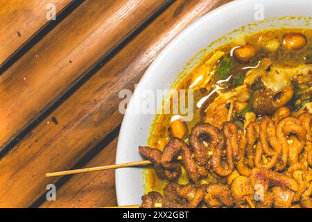 Bol de porridge de poulet servi avec des plats uniques. Porridge de poulet traditionnel avec des plats satay d'intestin de poulet, authentique traditionnel d'Indonésie Banque D'Images