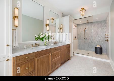 Salle de bains blanche avec meuble-lavabo en noyer et douche à l'italienne Banque D'Images