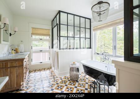 Salle de bains élégante avec touches noires et blanches et carrelage à motifs Banque D'Images