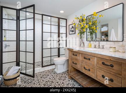 Salle de bains élégante avec carrelage en ciment à motifs et portes de douche en métal noir et en verre Banque D'Images