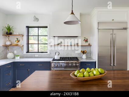 Cuisine avec armoires bleues et comptoirs en marbre blanc et comptoir îlot de noyer Banque D'Images