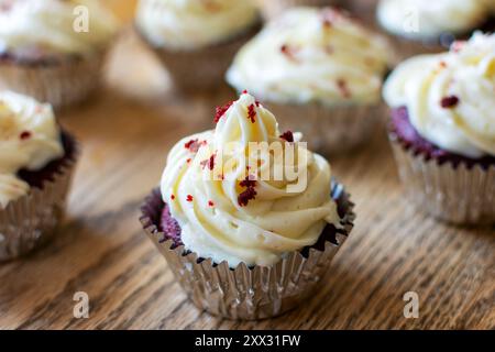 Cupcakes en velours rouge en feuille d'argent sur une table en bois. Banque D'Images