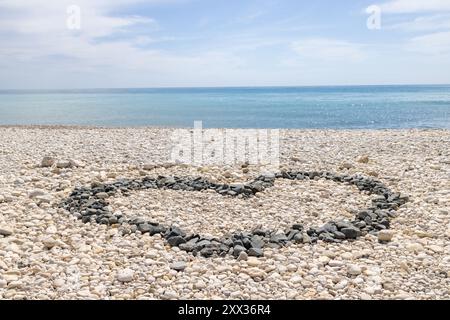 Photo du beau front de mer de la ville d'Altea à Alicante en Espagne montrant un cœur d'amour fait de pierres et de galets sur la plage Banque D'Images