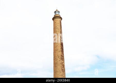 Phare contre ciel nuageux. Grande tour avec une lumière sur le dessus Banque D'Images
