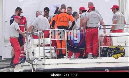 Le cinquième sac corporel est ramené à terre au port de Porticello par des sauveteurs à la recherche des six touristes disparus après que le yacht de luxe Bayesian a coulé dans une tempête lundi alors qu'il était amarré à environ 800 mètres au large de la côte sicilienne. Date de la photo : jeudi 22 août 2024. Banque D'Images