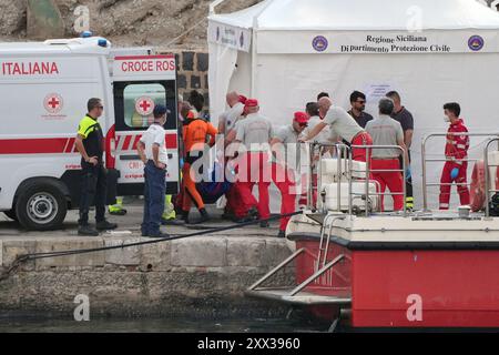 Le cinquième sac corporel est ramené à terre au port de Porticello par des sauveteurs à la recherche des six touristes disparus après que le yacht de luxe Bayesian a coulé dans une tempête lundi alors qu'il était amarré à environ 800 mètres au large de la côte sicilienne. Date de la photo : jeudi 22 août 2024. Banque D'Images