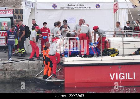 Le cinquième sac corporel est ramené à terre au port de Porticello par des sauveteurs à la recherche des six touristes disparus après que le yacht de luxe Bayesian a coulé dans une tempête lundi alors qu'il était amarré à environ 800 mètres au large de la côte sicilienne. Date de la photo : jeudi 22 août 2024. Banque D'Images