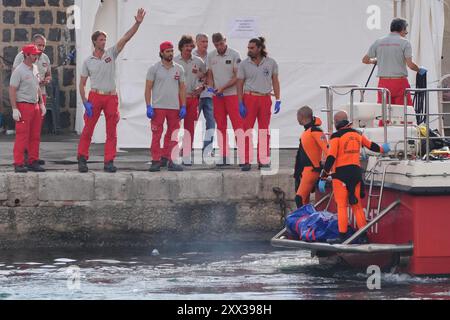 Le cinquième sac corporel est ramené à terre au port de Porticello par des sauveteurs à la recherche des six touristes disparus après que le yacht de luxe Bayesian a coulé dans une tempête lundi alors qu'il était amarré à environ 800 mètres au large de la côte sicilienne. Date de la photo : jeudi 22 août 2024. Banque D'Images