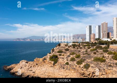 Photo drone aérienne de la partie nord de Benidorm en Espagne montrant les chemins rocheux au bord de l'océan et les appartements de grande hauteur par une journée ensoleillée dans le summ Banque D'Images