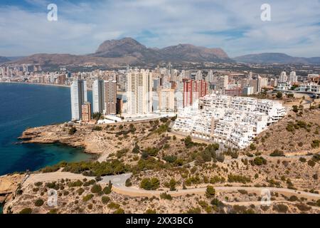 Photo drone aérienne de la partie nord de Benidorm en Espagne montrant les chemins rocheux au bord de l'océan et les appartements de grande hauteur par une journée ensoleillée dans le summ Banque D'Images