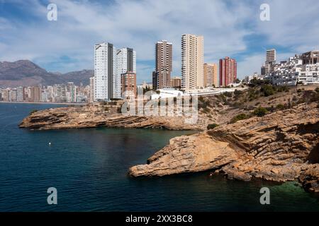 Photo drone aérienne de la partie nord de Benidorm en Espagne montrant les chemins rocheux au bord de l'océan et les appartements de grande hauteur par une journée ensoleillée dans le summ Banque D'Images