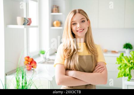 Photo de positive adorable fille croisée cuisiner dîner cuisine moderne lumière blanche à l'intérieur Banque D'Images