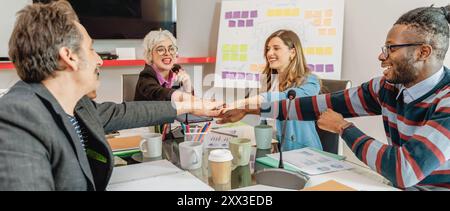 Groupe diversifié de professionnels s'engageant dans une séance de brainstorming créatif. Inclusivité au travail, travail d'équipe et innovation dans un coffret de bureau moderne Banque D'Images