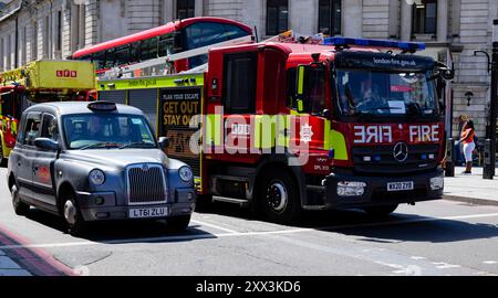 Londres - 06 14 2022 : camion de pompiers et un taxi arrêtés aux feux de circulation sur Wilton Rd Banque D'Images