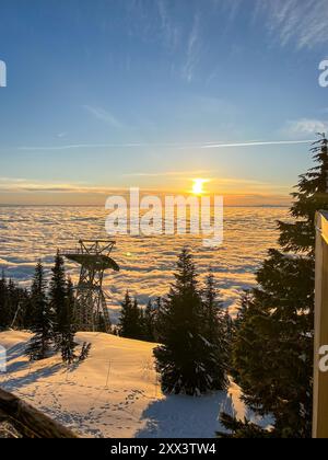Vue panoramique sur la télécabine Skyride au sommet de Vancouver, au-dessus des White Puffy Clouds, au coucher du soleil Banque D'Images