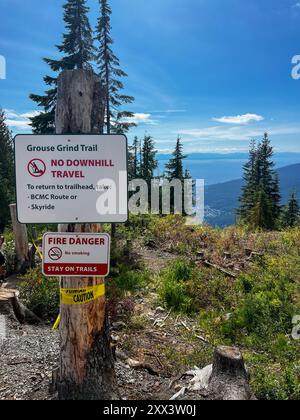 Cette photo capture un panneau sur le Grouse Grind Trail à Vancouver, avertissant les randonneurs de « pas de descente » et de « danger d'incendie ». Le panneau est placé au milieu Banque D'Images