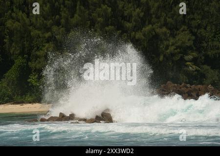 De grosses vagues se écrasent sur d'énormes pierres de granit sur l'île de Mahé, aux Seychelles Banque D'Images