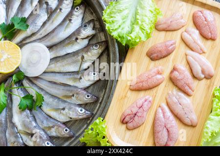 Caviar d'églefin non cuit avec du poisson d'églefin frais sur fond de bois Banque D'Images