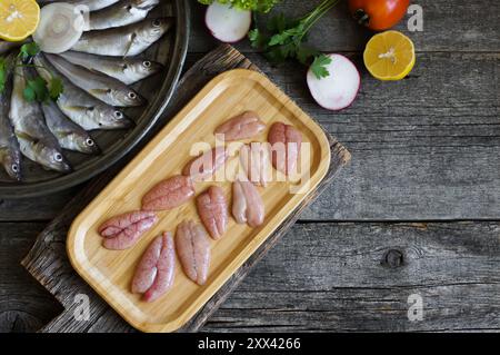 Caviar d'églefin non cuit avec du poisson d'églefin frais sur fond de bois Banque D'Images