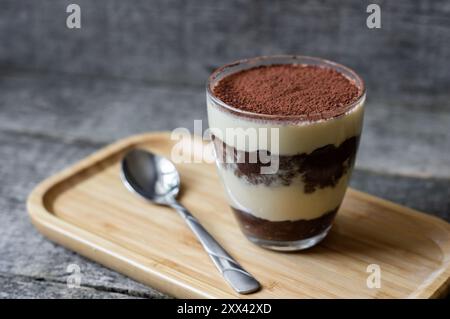 Tiramisu, dessert italien traditionnel en verre sur fond de bois. Mise au point sélective Banque D'Images