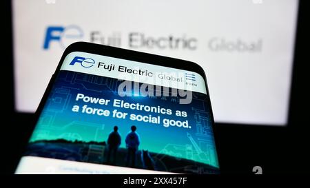 Smartphone avec le site Web de la société japonaise Fuji Electric Co. Ltd devant le logo de l'entreprise. Concentrez-vous sur le coin supérieur gauche de l'écran du téléphone. Banque D'Images