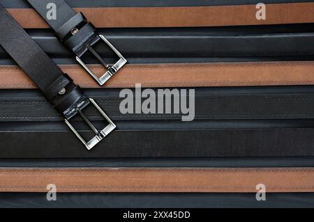 Concept de ceintures en cuir véritable et faux cuir, cuir marron et noir pour pantalon en denim, lin ou velours côtelé, ceinture élégante Banque D'Images