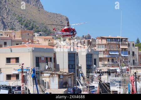 L'hélicoptère des pompiers retourne au port le quatrième jour de l'opération de recherche et de récupération après que le yacht de luxe Bayesian a coulé dans une tempête lundi alors qu'il était amarré à environ 800 mètres au large de la côte de Porticello, en Sicile. Les corps de cinq des personnes disparues ont été retrouvés mercredi, et quatre autres ont été retrouvés, mais on ignore où se trouve la sixième personne disparue. Date de la photo : jeudi 22 août 2024. Banque D'Images