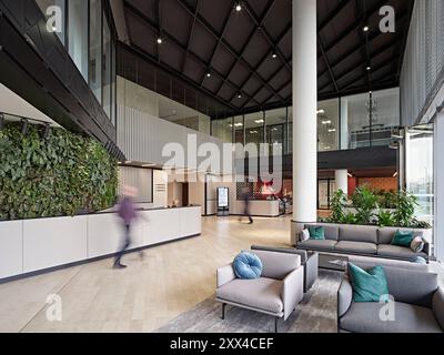 Foyer avec bureau de réception et salon d'attente, chiffres passant. Bâtiment 1180, Reading, Royaume-Uni. Architecte : Spratley + Partners, 2022. Banque D'Images