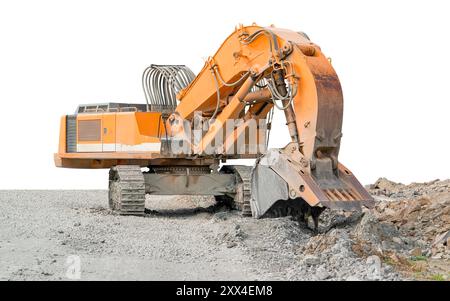 Énorme excavatrice à chenilles de couleur orange partiellement isolée sur un sol pierreux Banque D'Images