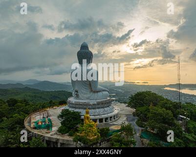 Une vue aérienne majestueuse du grand Bouddha de Phuket baigné dans la lumière dorée du soleil tandis que la brume roule sur les collines environnantes. Le serein capture la esse spirituelle Banque D'Images