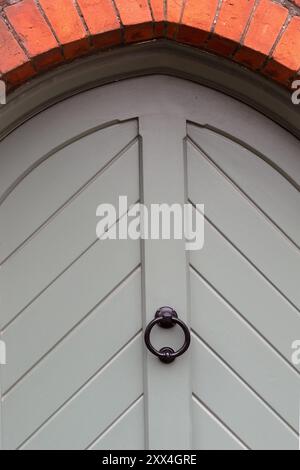 Porte arquée en bois gris et heurtoir de porte Banque D'Images