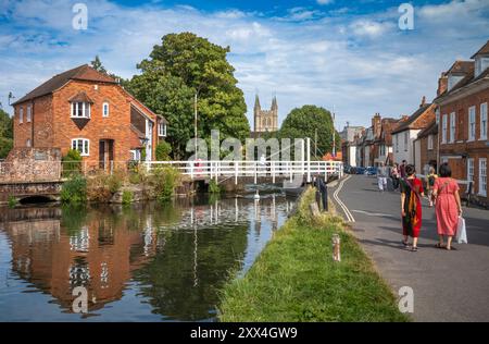 Les gens marchent près de West Mills Swing Bridge sur le canal Kennet et Avon, avec l'église St Nicolas en arrière-plan, Newbury, Berkshire, Royaume-Uni. Banque D'Images