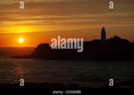 Coucher de soleil sur le phare de Godrevy vu du sommet de la falaise près de la côte de Gwithian, Cornwall, Royaume-Uni Banque D'Images