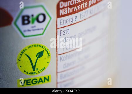 Les sceaux 'Bio selon EC-Oeko-Verordnung' et 'V-Label International Vegan' sont imprimés sur l'étiquette d'une pâte à tartiner. Berlin, le 22 août 2024. Banque D'Images