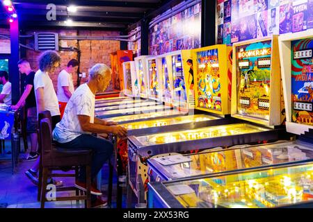 Les gens jouant sur des machines de flipper au Musée interactif de Pinball 'Pinball Station', Varsovie, Pologne Banque D'Images