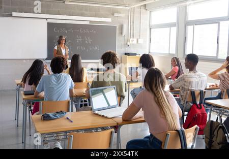 Enseignante expliquant la science à une classe d'élèves adolescents divers. Lycée, collège, étudiants en classe Banque D'Images