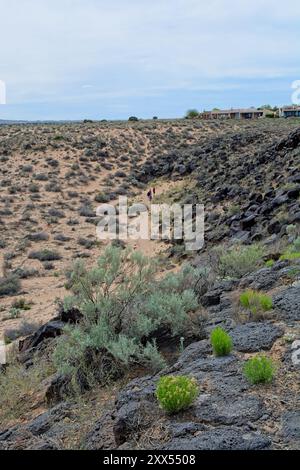 Randonneurs sur le sentier de la vallée du canyon en dessous de l'expansion urbaine au Petroglyph National Monument Banque D'Images