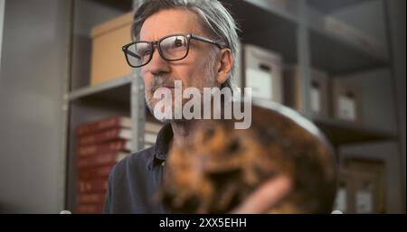 Deux archéologues analysent et examinent le crâne de l'homme éteint antique, ont des discussions au cours de recherches historiques et scientifiques sur les restes fossiles. Les scientifiques travaillent dans un laboratoire archéologique moderne. Banque D'Images