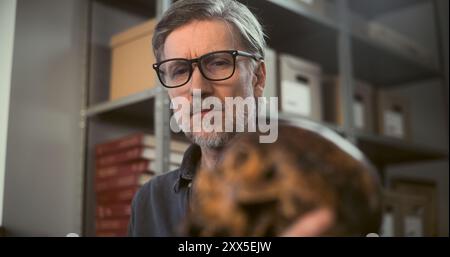 Deux archéologues analysent et examinent le crâne de l'homme éteint antique, ont des discussions au cours de recherches historiques et scientifiques sur les restes fossiles. Les scientifiques travaillent dans un laboratoire archéologique moderne. Banque D'Images