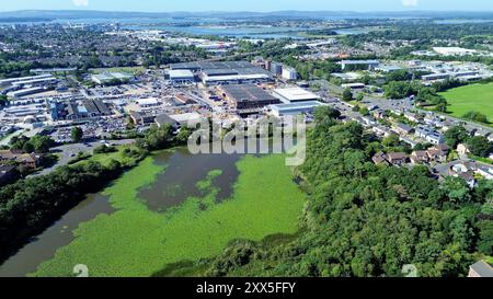 Une vue aérienne regardant vers le bas sur la réserve naturelle locale de Hatch Pond avec une zone industrielle et Poole Harbour en arrière-plan Banque D'Images