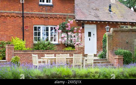 Extérieur de la grande maison britannique. Maison de campagne et jardin avec meubles de patio en bois Banque D'Images