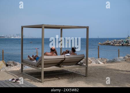 Barcelone, Espagne. 22 août 2024. Les clients du W Barcelona Hotel sont vus en suivant la régate depuis la plage privée de l'hôtel, installée en face de la zone de régate. La Louis Vuitton Preliminary Regatta 2024 America's Cup a entamé les premières courses préliminaires ce matin. Visiteurs, touristes et résidents ont pu profiter gratuitement de la première course de la compétition depuis les points de vue sur le front de mer et sur de grands écrans situés dans les zones de fans. Crédit : SOPA images Limited/Alamy Live News Banque D'Images