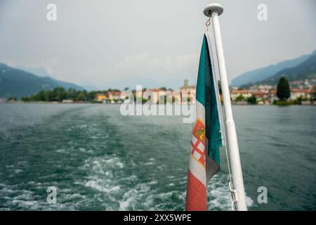Mandello del Lario, Italie - 08 juin 2024 : un petit village au bord du lac de Côme. Drapeau de la province de Côme en évidence. Banque D'Images