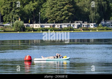 Lac Baldeney, Ruhrstausee, SUP comme une île de lecture, jeune femme profitant de l'été, sur son stand-up paddle board, amarré à une bouée, Essen, North RHI Banque D'Images