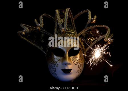 Den Helder, pays-Bas. Décembre 2022. Masque de carnaval vénitien sur fond noir avec des étincelles. Banque D'Images