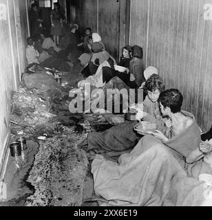 Survivantes dans des conditions sordides après leur libération du camp de concentration de Bergen-Belsen. La position du camp dans l'ouest de l'Allemagne signifiait que des milliers de personnes y furent envoyées alors que l'est tombait. 18000 personnes sont mortes rien qu'en mars 1945, et 10000 dans les deux semaines qui ont suivi la libération. Ils sont morts de maladie et de négligence plutôt que des abus systématiques observés ailleurs. Banque D'Images