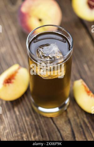 Ice Tea peach frais (selective focus) sur une vieille table en bois (gros plan) Banque D'Images
